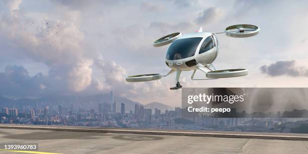 evtol electric vertical take off and landing aircraft about to land near city - taxi van stockfoto's en -beelden