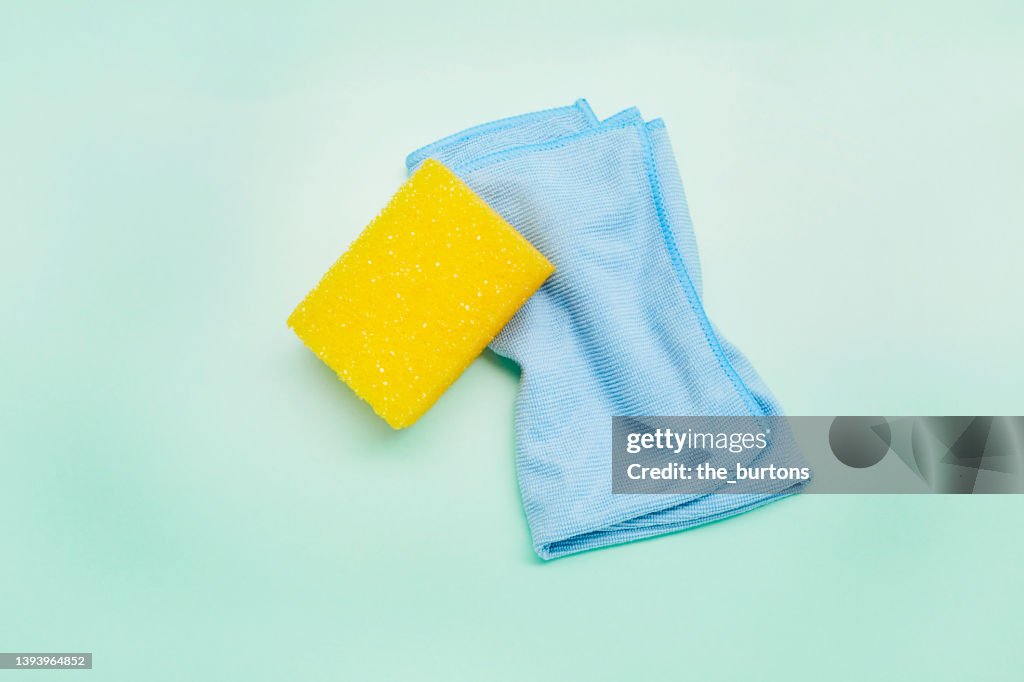 High angle view of sponge and cleaning cloth on turquoise background, house cleaning