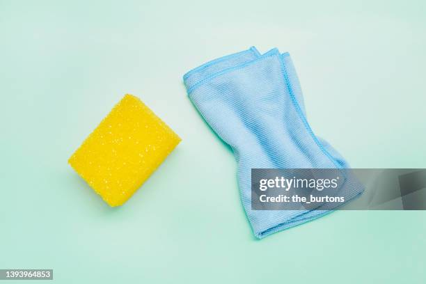 high angle view of sponge and cleaning cloth on turquoise background, house cleaning - pano da loiça imagens e fotografias de stock