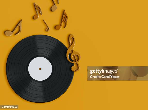 vinyl record album with musical notes in orange  background - grooved fotografías e imágenes de stock