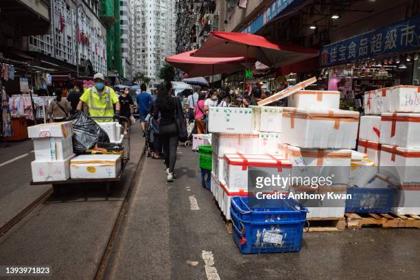 Worker cleans up styrofoam containers piling up on the side of a street at a wet market on April 26, 2022 in Hong Kong, China. Styrofoam containers...