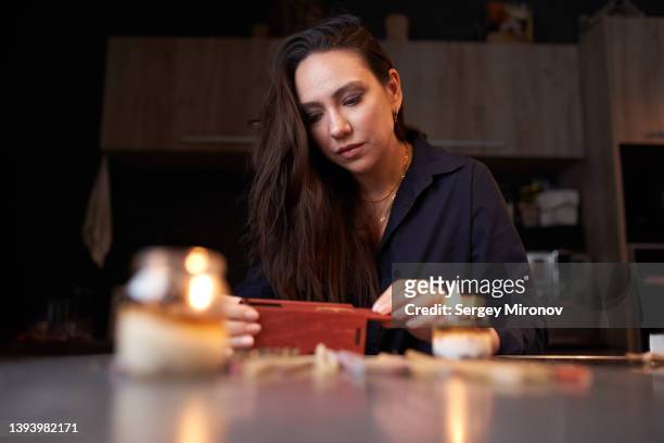 woman arranging incense sticks and candles at home - ceremony fotografías e imágenes de stock