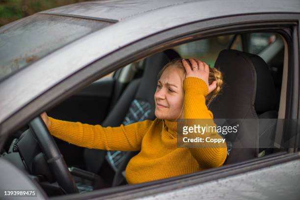 junge frau, die in ihrem auto sitzt und probleme hat - man driving anxiously stock-fotos und bilder