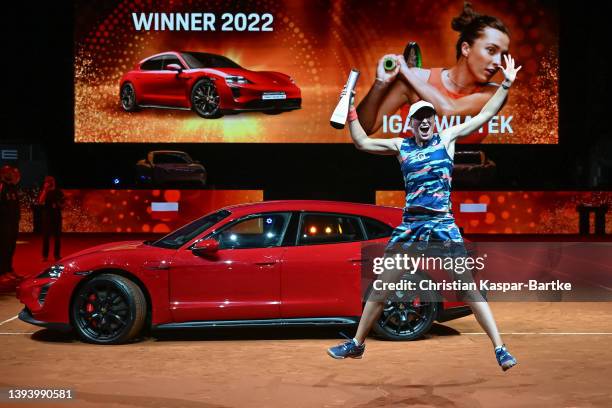 Iga Swiatek of Poland reacts during the trophy presentation as she beats Aryna Sabalenka in their final match during day seven of the Porsche Tennis...