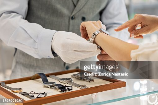 Joven irreconocible probando un reloj de pulsera en joyería Joven irreconocible probando un reloj de pulsera en joyería