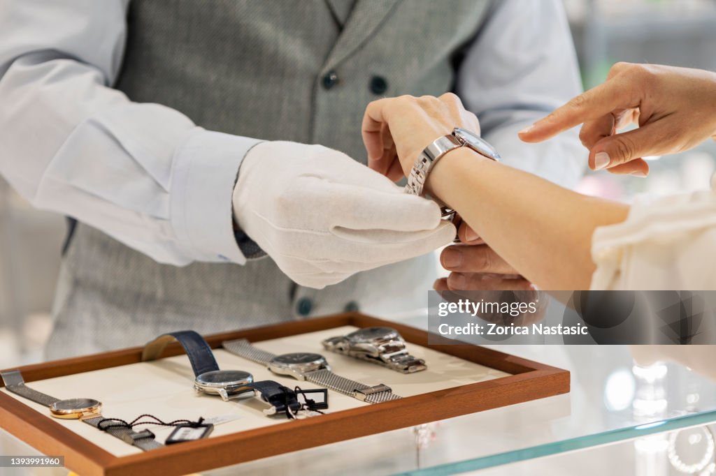 Young unrecognizable woman trying a wristwatch in jewelry store