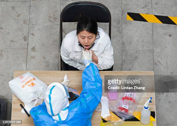 Medical worker wearing protective suits take swab samples from residents for nucleic acid testing at a community in Chaoyang District on April 27,...