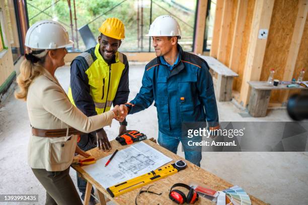 businesswoman and contractor closing a deal - building contractor stock pictures, royalty-free photos & images