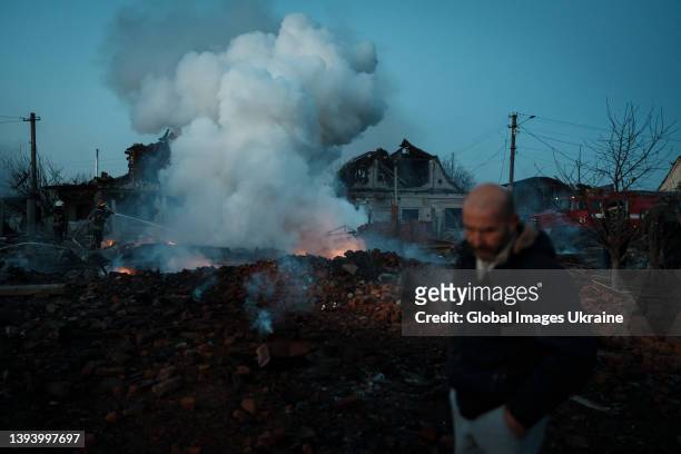 Man stands beside the smoking ruins of a house after a Russian missile attack on March 17, 2022 in the Brovary Raion, Kyiv Oblast, Ukraine. Russian...
