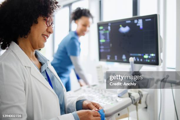 le médecin fait un examen échographique de la femme enceinte - medical scanner stock photos et images de collection