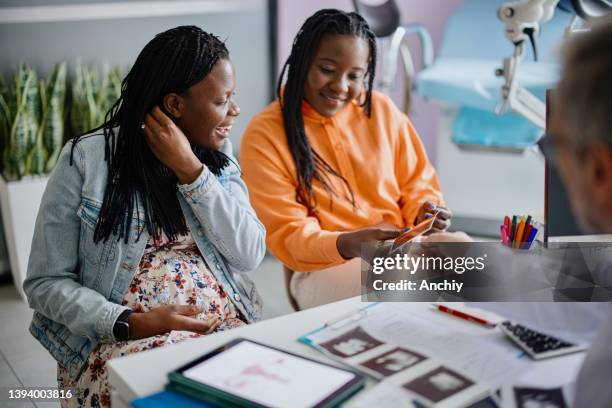 doctor showing sonogram to same sex couple - doctor and baby stock pictures, royalty-free photos & images