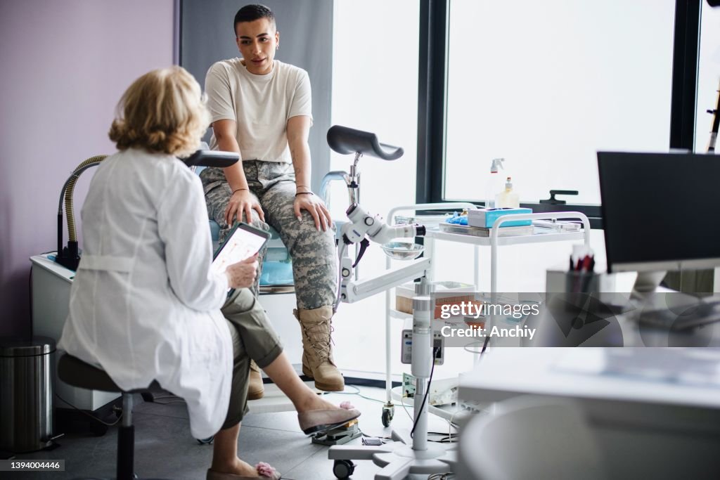 Gynecologist doctor going over test results with soldier patient