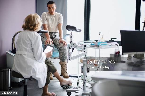 gynecologist doctor going over test results with soldier patient - human papilloma virus stock pictures, royalty-free photos & images