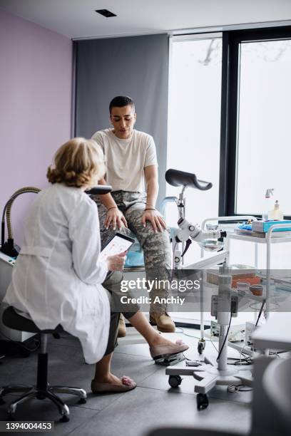 médico ginecólogo revisando los resultados de las pruebas con paciente soldado - papanicolau fotografías e imágenes de stock