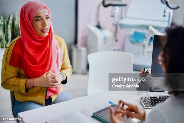 una paziente musulmana esamina i risultati dei test medici con la sua ginecologa - cultura araba foto e immagini stock