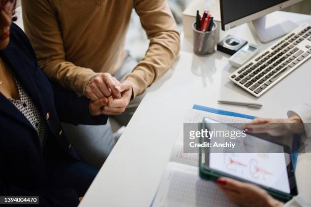 close up shot of a couple holding hands in comfort - married doctor stock pictures, royalty-free photos & images
