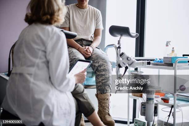 soldato irriconoscibile che parla con una dottoressa - ginecologo foto e immagini stock