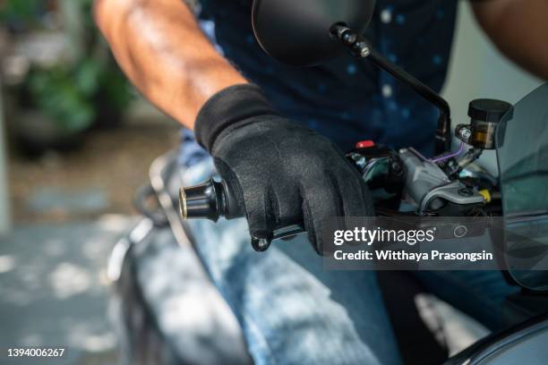 biker's hand on brake lever handlebar - トレーニンググローブ ストックフォトと画像