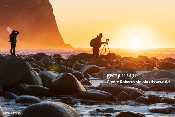tourists photographing the sea at sunset, norway - photographer stock pictures, royalty-free photos & images