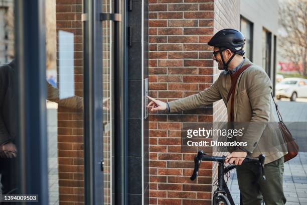 man rings on the intercom - apartment entry stock pictures, royalty-free photos & images