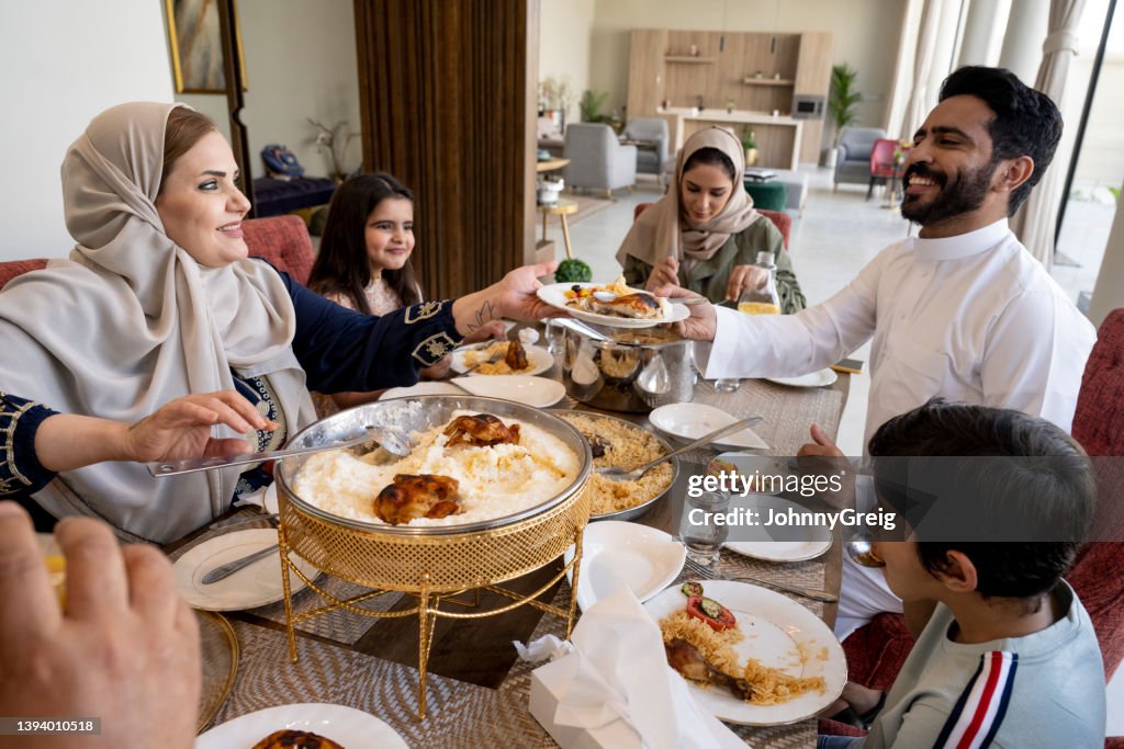 Mature Saudi woman serving saleeg to family member