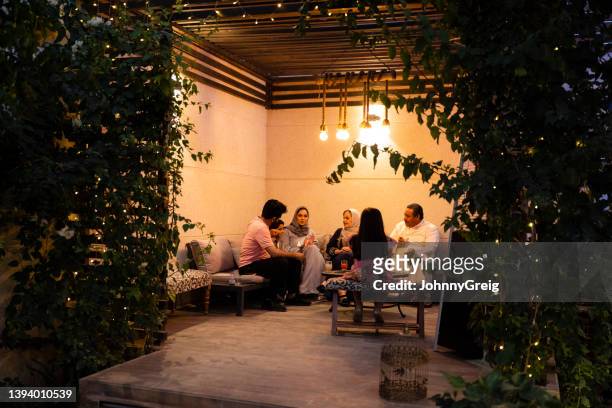 multi-generation saudi family relaxing outdoors at night - arabic family imagens e fotografias de stock