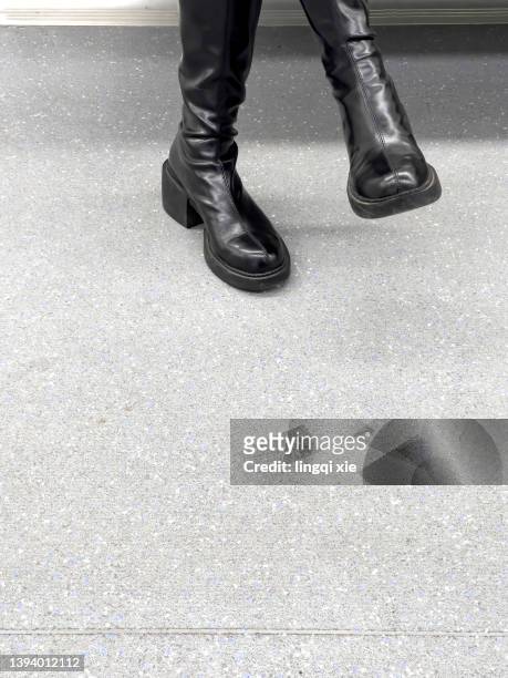 a woman in leather boots sits on the subway with her legs crossed - crossed legs heels stock pictures, royalty-free photos & images