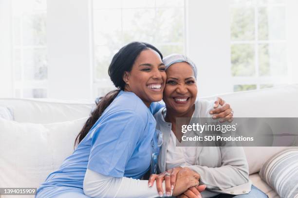 elderly woman enjoys her nurse - healthcare worker stockfoto's en -beelden