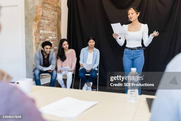 young woman presents monologue to unrecognizable judges in foreground - acting 個照片及圖片檔