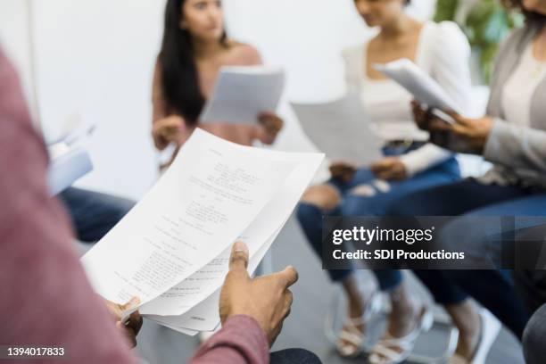 focus on script in foreground as actors discuss parts - guião imagens e fotografias de stock