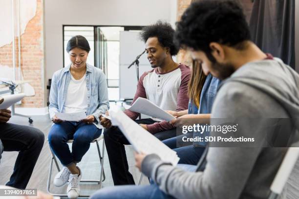 le groupe multiracial se trouve en cercle pour lire les parties - faire du théâtre photos et images de collection