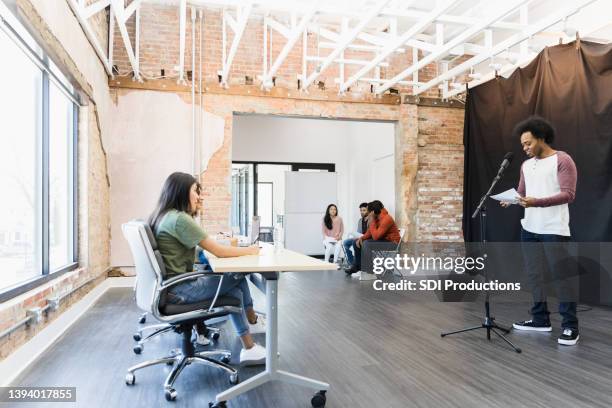 man reads for part in front of casting directors - audition stockfoto's en -beelden