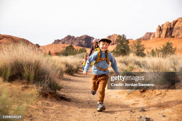 a young boy smiles while running down a trail. - hiking utah stock pictures, royalty-free photos & images