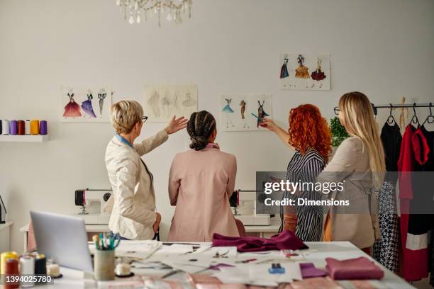 quatre collègues féminines travaillant sur leur design de mode - fashion photos et images de collection