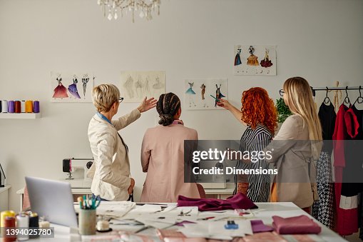 Four female coworkers working on their fashion design Four female coworkers working on their fashion design