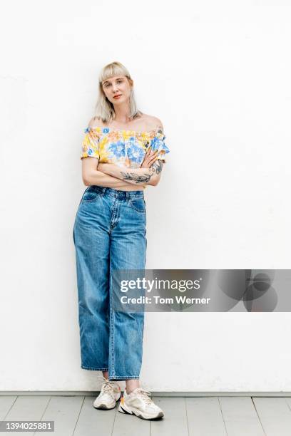 portrait of blond woman in high waisted jeans - portrait of young woman standing against steps stockfoto's en -beelden