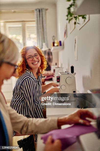 smiling seamstress working on sewing machine - sewing craft stock pictures, royalty-free photos & images