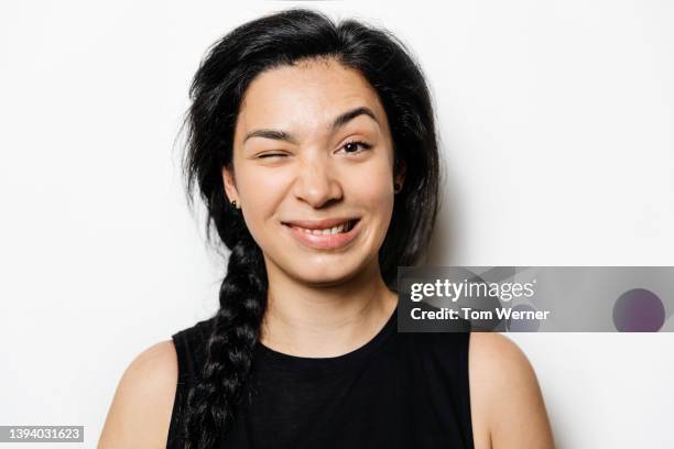 portrait of woman with dark hair pulling silly face - augenbraue hochziehen stock-fotos und bilder