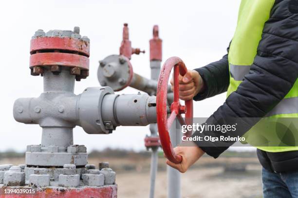 stationary or technical unrecognizable engineer turning on off vent of gas pump - oleodotto foto e immagini stock