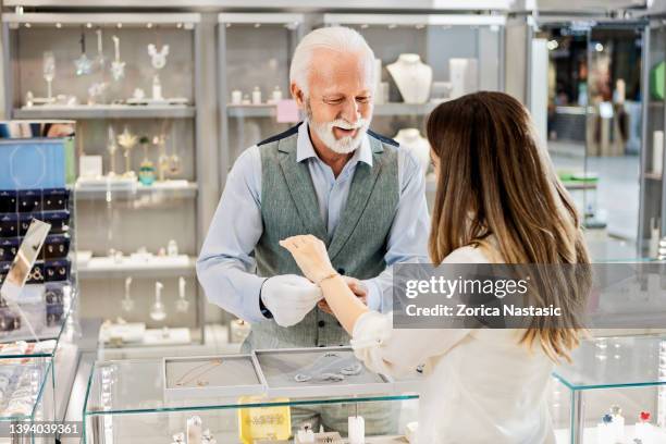 young woman trying on a diamond bracelet at a jewelry - bracelet bildbanksfoton och bilder