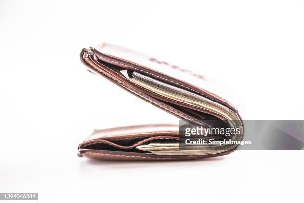 leather wallet full of banknotes on a white background. - wage gap stock pictures, royalty-free photos & images