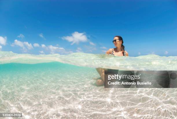 elegant woman relaxing in cristal clear water of pigeon cays - roatan stock pictures, royalty-free photos & images