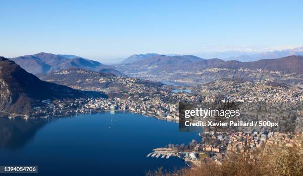 aerial view of city by sea against clear blue sky,lugano,switzerland - lugano stock-fotos und bilder