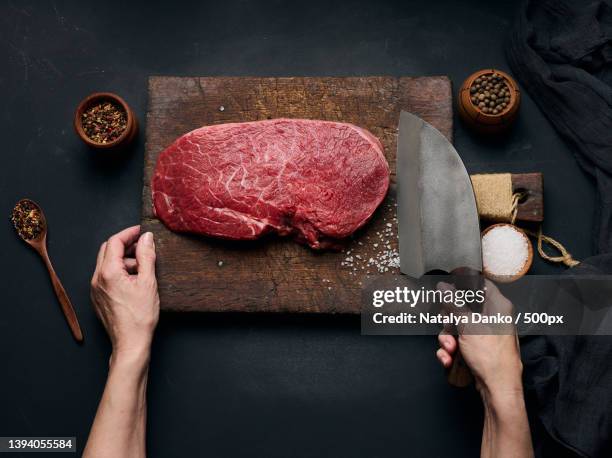 raw beef tenderloin lies on a wooden cutting board - butcher knife stock pictures, royalty-free photos & images