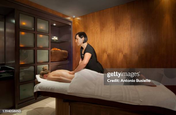 massage in luxury hotel spa - massage table stock pictures, royalty-free photos & images