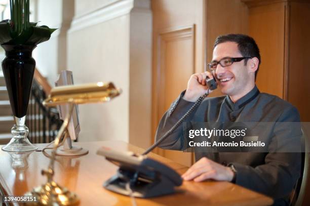 concierge talking on the phone - receptiebel stockfoto's en -beelden