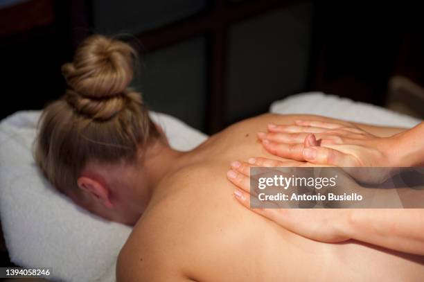 massage therapist hands on a young blood girl back. - マッサージ台 ストックフォトと画像