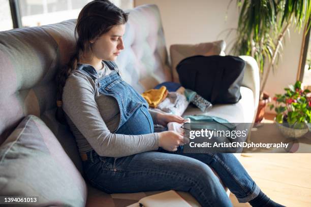 pregnant woman preparing bag for the hospital for childbirth. - new sofa stock pictures, royalty-free photos & images