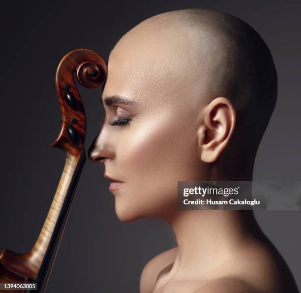 portrait of cancer survivor bald woman posing with her violin. - beautiful woman violinist stock pictures, royalty-free photos & images