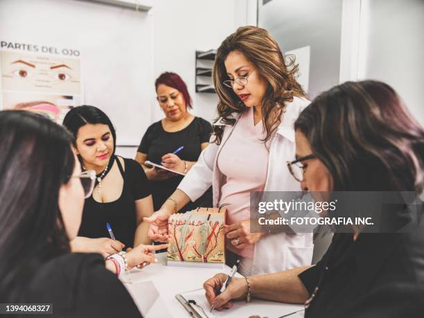 female beautician instructor teaching women at the class - tratamento de beleza ocupação imagens e fotografias de stock
